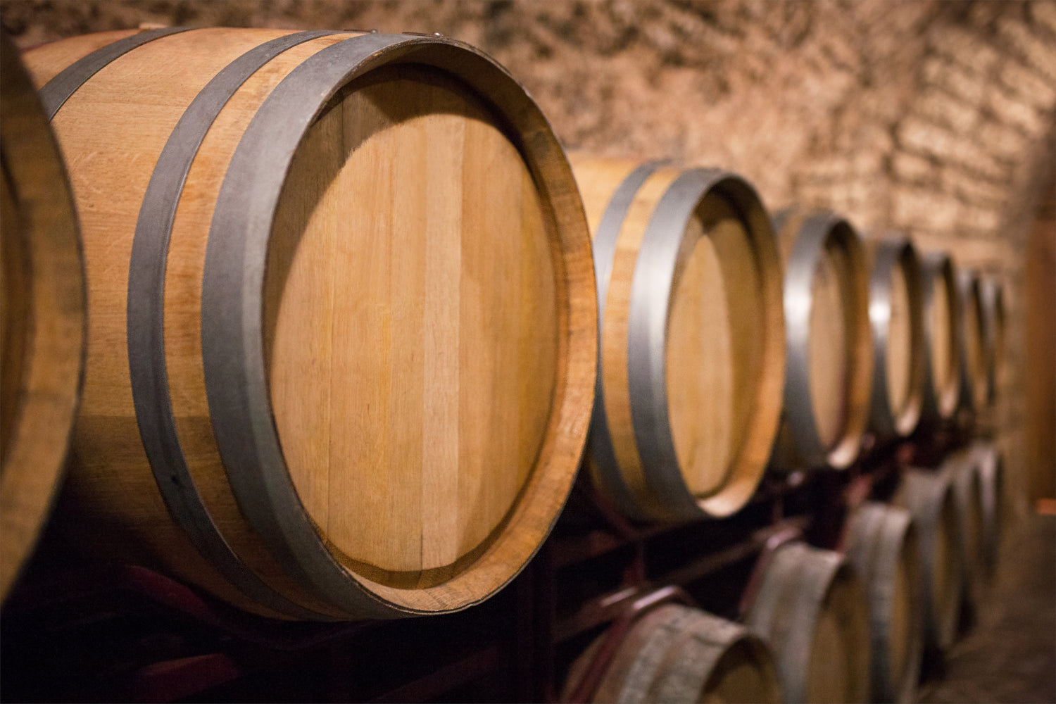 Row of wooden wine barrels in a wine cellar